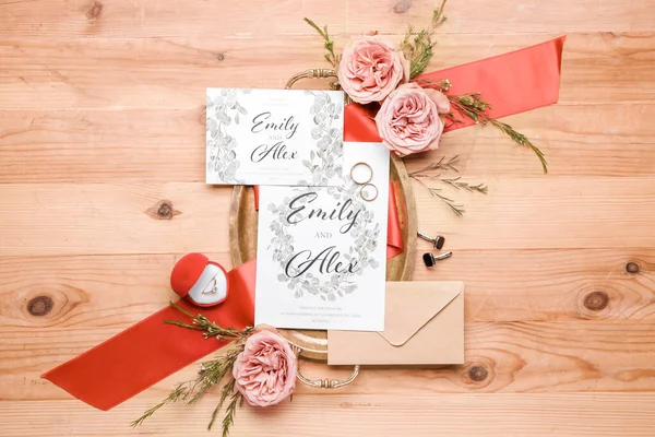 Beautiful composition with wedding invitations on wooden background