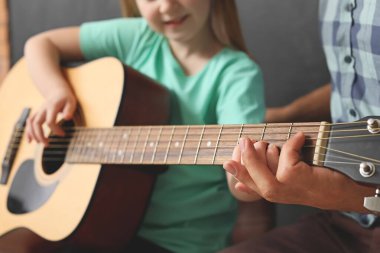 Müzik okulunda gitar çalan küçük kız, yakın plan.