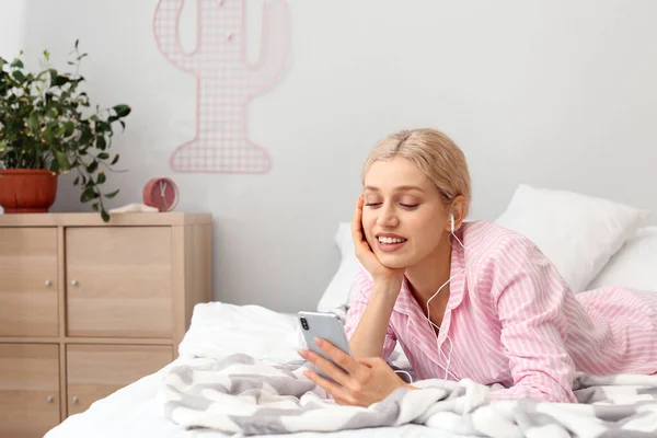 Jonge Vrouw Met Mobiele Telefoon Luisteren Naar Muziek Slaapkamer — Stockfoto