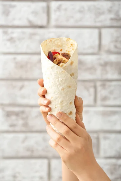 Mãos Femininas Com Saboroso Doner Kebab Fundo Tijolo — Fotografia de Stock