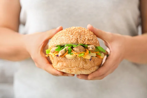 Woman with tasty doner kebab in bun, closeup