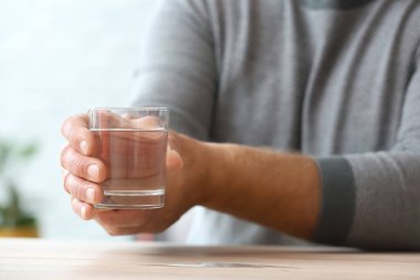 Parkinson sendromlu yaşlı adam evinde su içiyor, yakın plan.