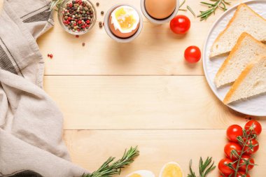 Ahşap zemin üzerinde pişmiş yumurta, ekmek ve baharattan yapılmış çerçeve.