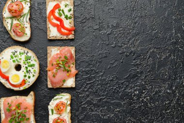 Koyu arka planda lezzetli krem peynirli farklı sandviçler.