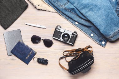 Aksesuarlı şık erkek kıyafetleri ve beyaz tahta arka planda fotoğraf makinesi.