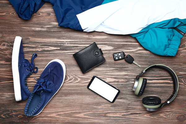 Стильная мужская одежда с аксессуарами и устройствами на деревянном фоне
