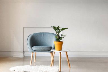 Koltuklu aydınlatma odasının içi ve çiçekli bir masa.