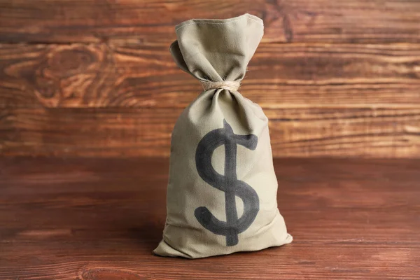 Bag with money on wooden background