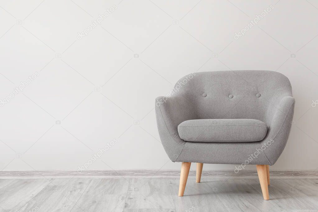 Armchair near white wall in room