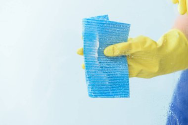 Temizlikçi renk arkaplanına karşı pencereyi temizliyor