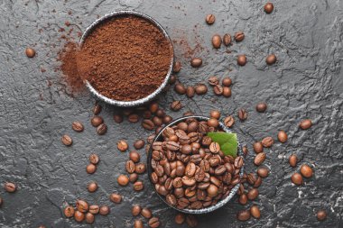 Kahve çekirdekli kaseler ve gri arka planda pudra.