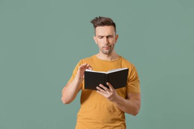 Genç adam renk arkaplanı kitabı okuyor