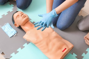 CPR ilk yardım eğitim kursu, manken üzerinde gösteren eğitmen
