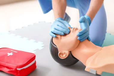 CPR ilk yardım eğitim kursu, manken üzerinde gösteren eğitmen
