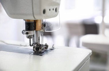 Modern dikiş makinesi terzi atölyesinde, yakın çekim.