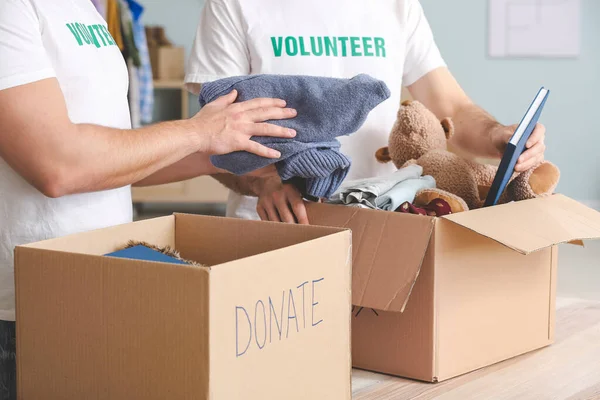 貧しい人々への寄付を屋内で行うボランティア — ストック写真