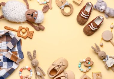 Renk arkaplanındaki bebek kıyafetlerinden ve aksesuarlarından yapılmış çerçeve