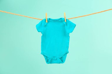Bebek kıyafetleri renk arkaplanında ipte sallanıyor