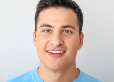 Hafif arka planda gülümseyen yakışıklı adam.