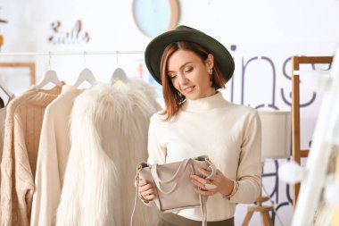 Stüdyosunda çantası olan kadın stilisti.