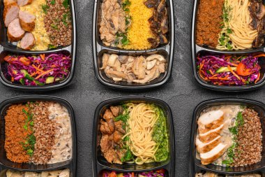 Karanlık arka planda sağlıklı yiyecekleri olan kaplar.