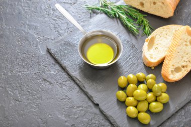 Koyu arkaplanda lezzetli zeytinyağı ve ekmek.