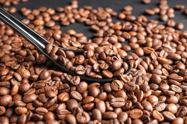 Viele Kaffeebohnen Und Löffel Auf Dunklem Hintergrund — Stockfoto