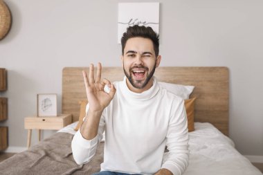 Genç adam evde video sohbeti yapıyor.