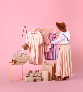 Renkli arka planda modern giysileri olan kadın stilisti