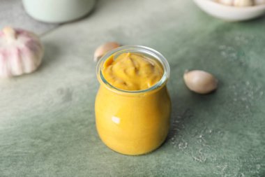 Jar of tasty honey mustard sauce on color background
