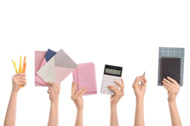 Beyaz arka planda okul malzemesi olan bir sürü el.