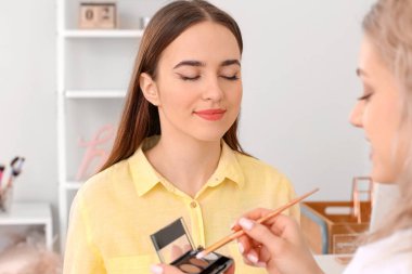 Profesyonel makyaj sanatçısı salon genç kadın ile çalışma