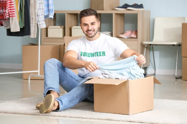 Volunteer packing clothes for poor people in box