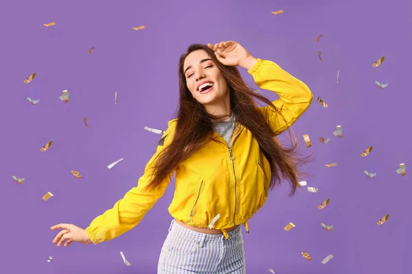 Stylish young woman and falling confetti on color background