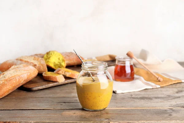 Jar of tasty honey mustard sauce on wooden table