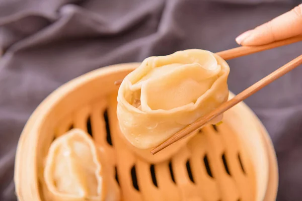 Eating of tasty oriental dumplings, closeup