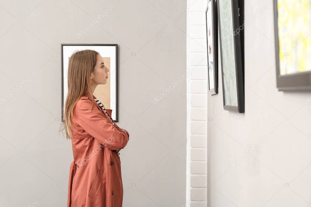 Young woman at exhibition in modern art gallery