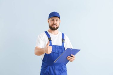 Renkli arka planda Thumb-Up gösteren yakışıklı tesisatçı