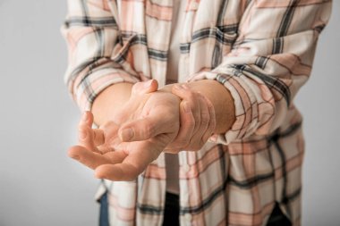 Gri arka planda Parkinson sendromu olan yaşlı kadın, yakın plan.