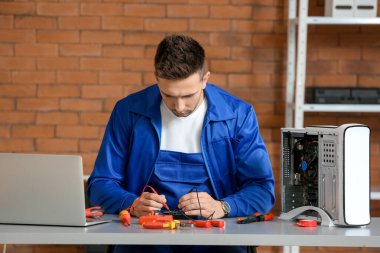 Electronic technician repairing computer in service center