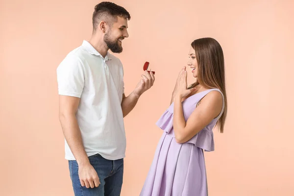 Junger Mann Macht Seiner Geliebten Auf Farbigem Hintergrund Einen Heiratsantrag — Stockfoto