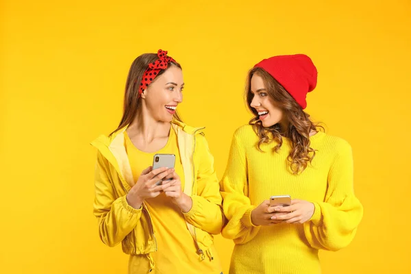 Junge Frauen Mit Mobiltelefonen Auf Farbigem Hintergrund — Stockfoto