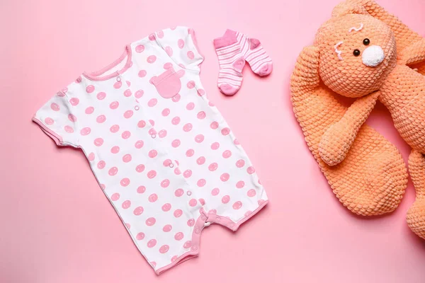 Babykleidung Mit Spielzeug Und Socken Auf Farbigem Hintergrund — Stockfoto