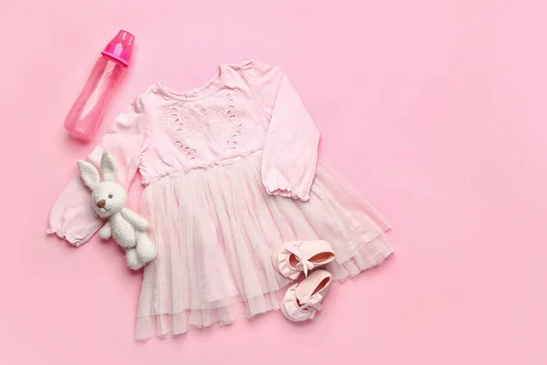 Babykleidung Mit Spielzeug Booties Und Flasche Auf Farbigem Hintergrund — Stockfoto