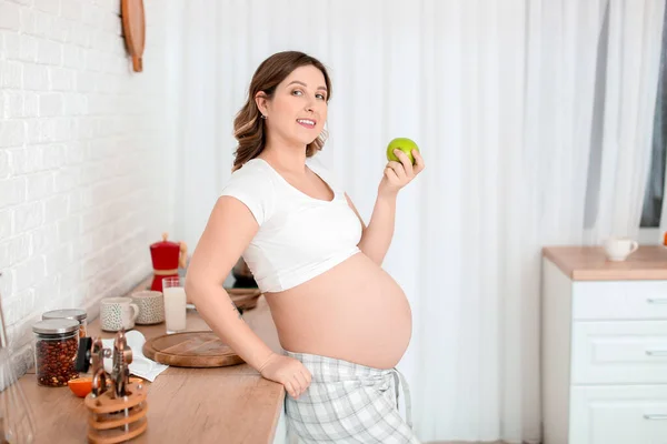 美しいです妊娠中の女性とともにリンゴでキッチン — ストック写真