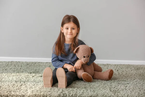 Cute Little Girl Niedźwiedź Zabawka Pobliżu Szarej Ściany — Zdjęcie stockowe