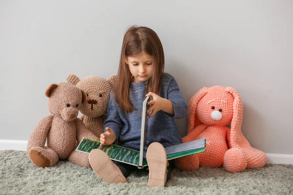 Cute Little Girl Toys Reading Book Home — Stock Photo, Image