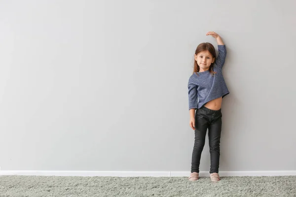 Menina Medindo Altura Perto Parede Cinza — Fotografia de Stock