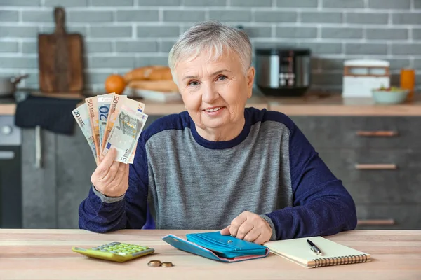 Senior woman counting money at home
