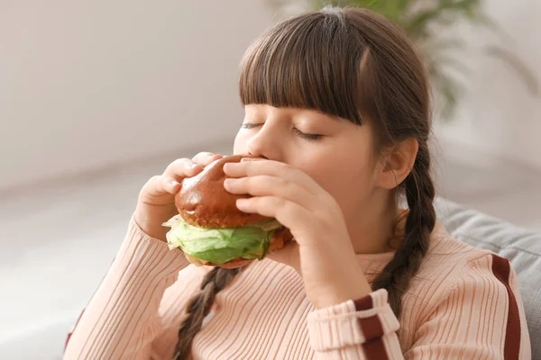 太りすぎ女の子食べる不健康なハンバーガーに家 — ストック写真